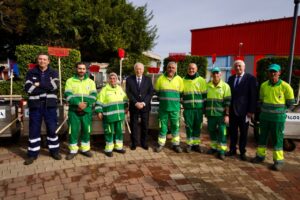 Grupo de trabajadores con carritos eléctricos de limpieza en la ciudad