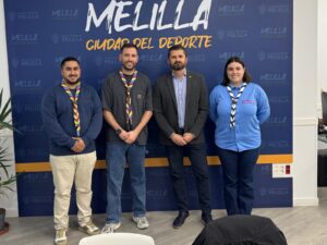 Grupo de personas en una reunión en Melilla con bufandas de scouts