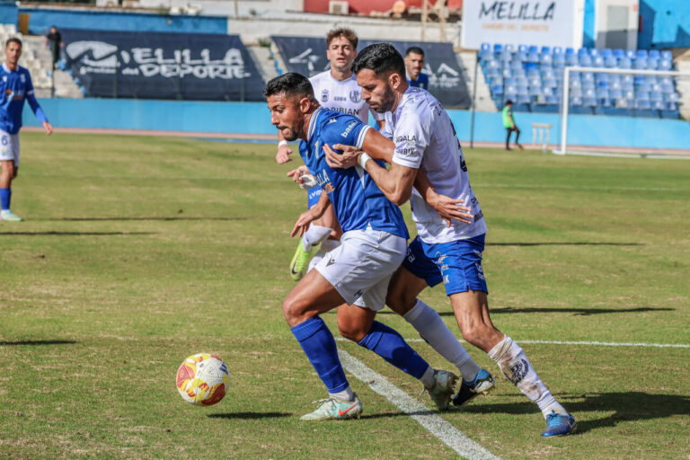 Jugadores de la U.D. Melilla compitiendo en un partido de fútbol