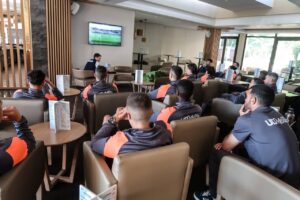 Jugadores de la U.D. Melilla viendo un partido en un salón.