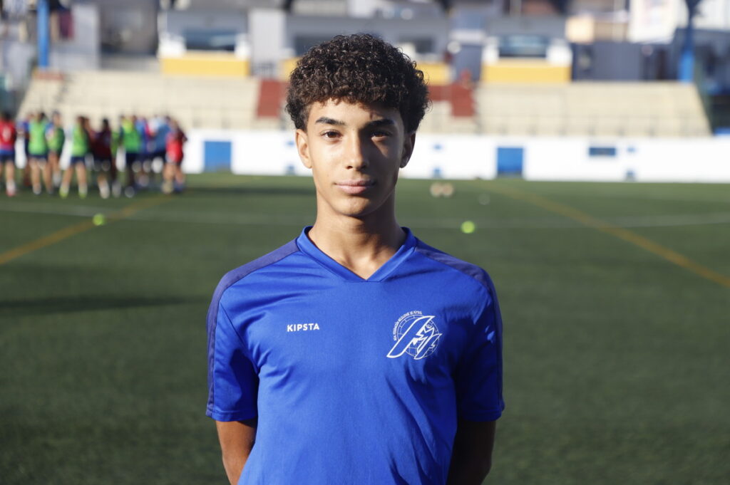 Joven futbolista de Melilla en uniforme azul en un campo de fútbol
