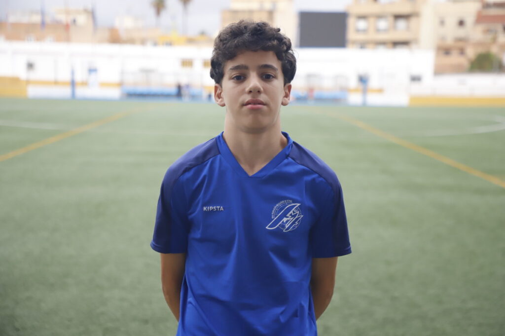 Jugador de fútbol melillense en camiseta azul en campo de fútbol