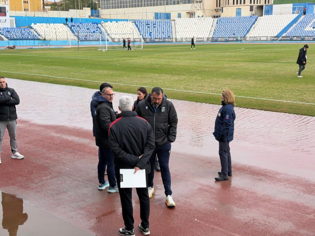 Reunión de directivos en el campo de fútbol antes del partido aplazado.