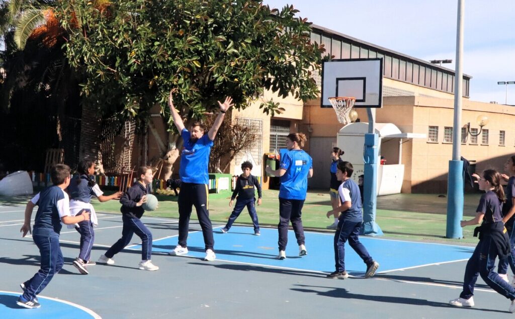 Niños jugando baloncesto en una cancha al aire libre