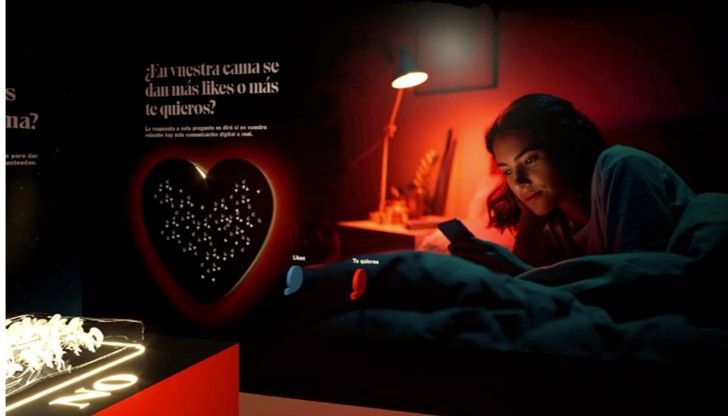 Mujer en la cama usando su teléfono en el Museo de la Intimidad