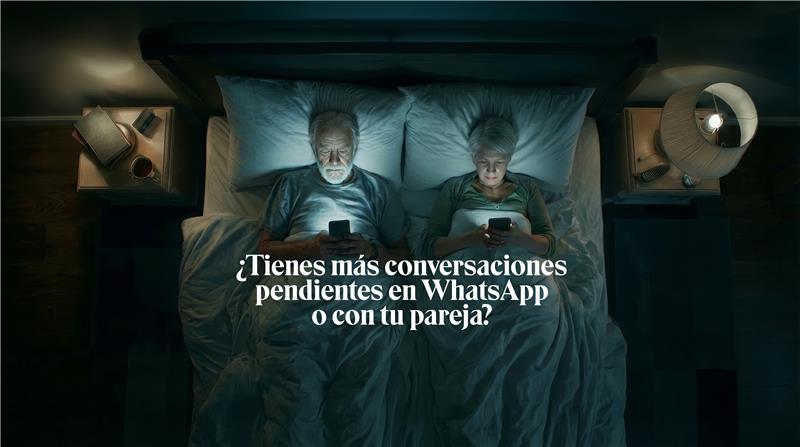 Pareja en la cama usando teléfonos móviles por la noche