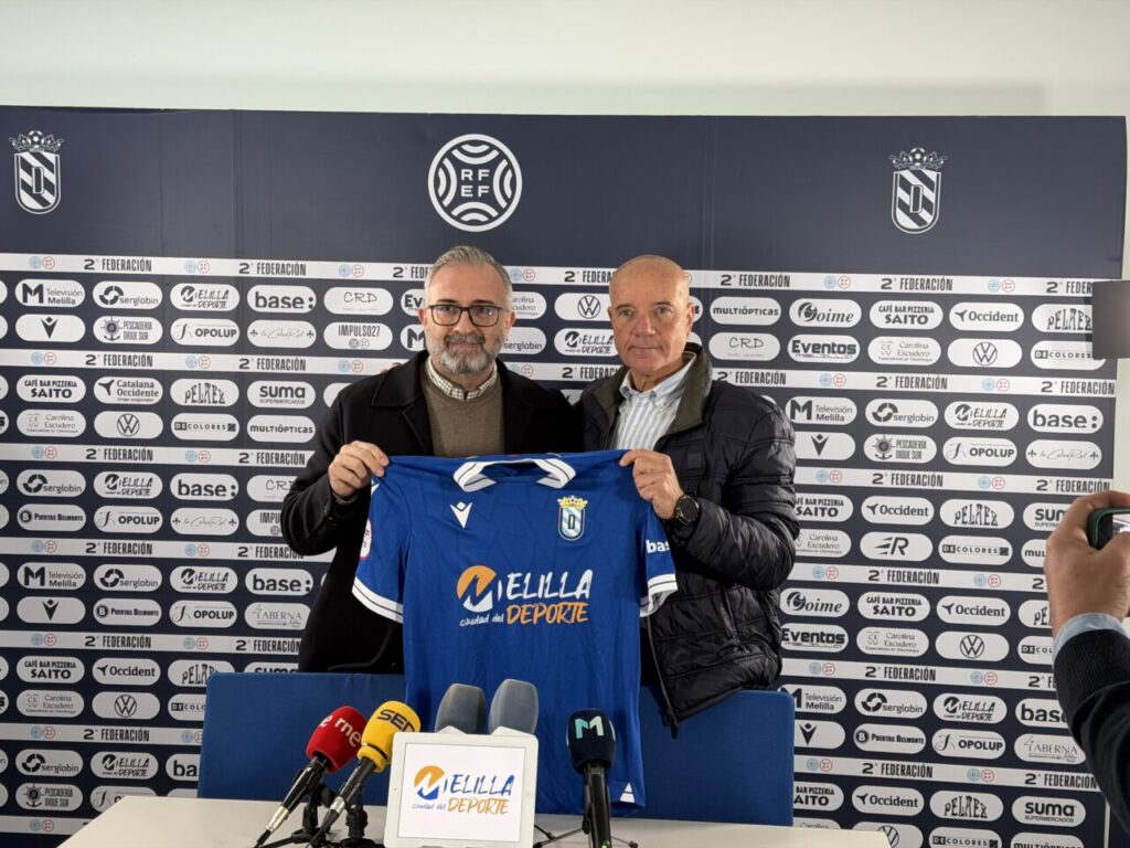Miguel Rivera sosteniendo la camiseta de la U.D. Melilla durante su presentación como entrenador.