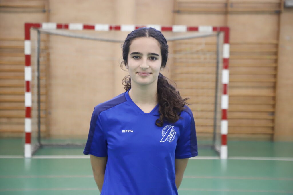 Jugadora de fútbol sala femenino en uniforme azul sonriendo en un pabellón