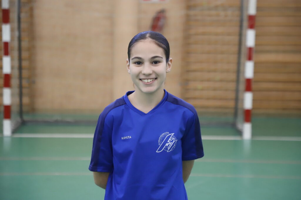 Jugadora sonriente de fútbol sala femenino Sub-14 en un pabellón