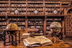 Vista de la biblioteca de la Universidad de Salamanca con libros antiguos y globos terráqueos.