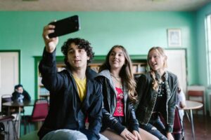 Tres adolescentes tomando un selfie en un ambiente escolar