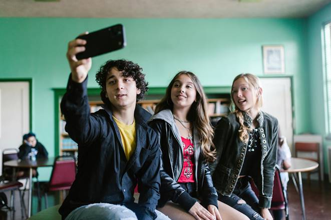 Tres adolescentes tomando un selfie en un ambiente escolar