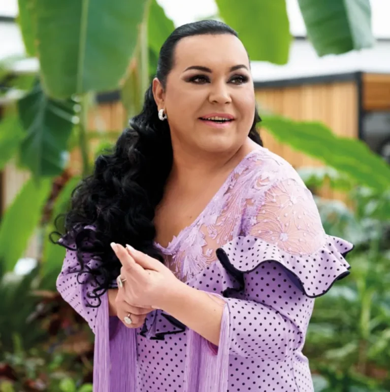 Falete sonriente con un vestido morado en un entorno natural