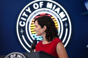 Isabel Díaz Ayuso durante un evento en Miami con el logo de la ciudad de fondo