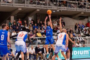 Jugador del Club Melilla lanzando a canasta durante un partido de baloncesto