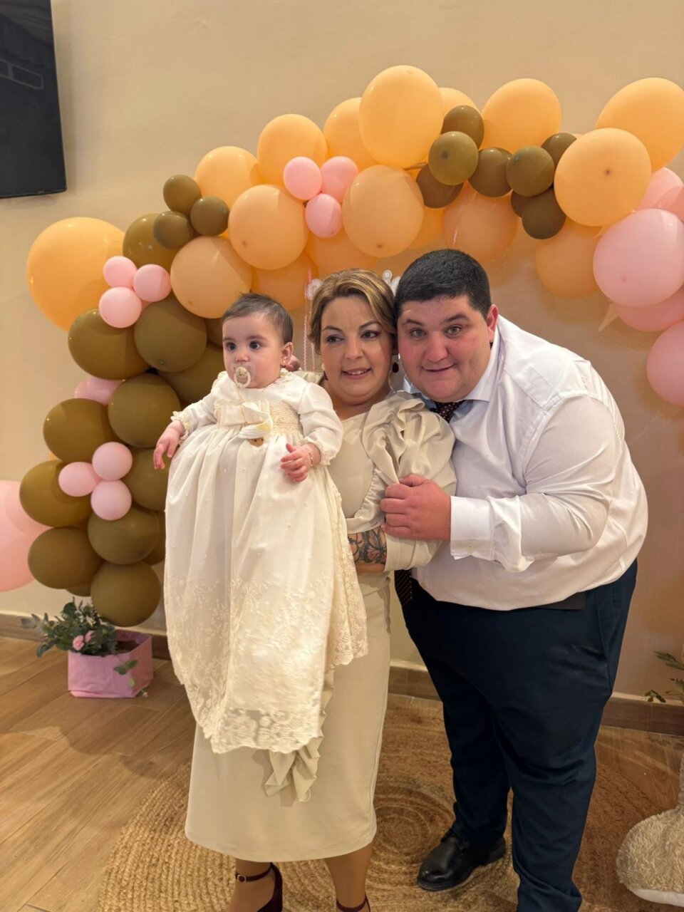 Familia celebrando el bautizo de Mariana con globos de colores