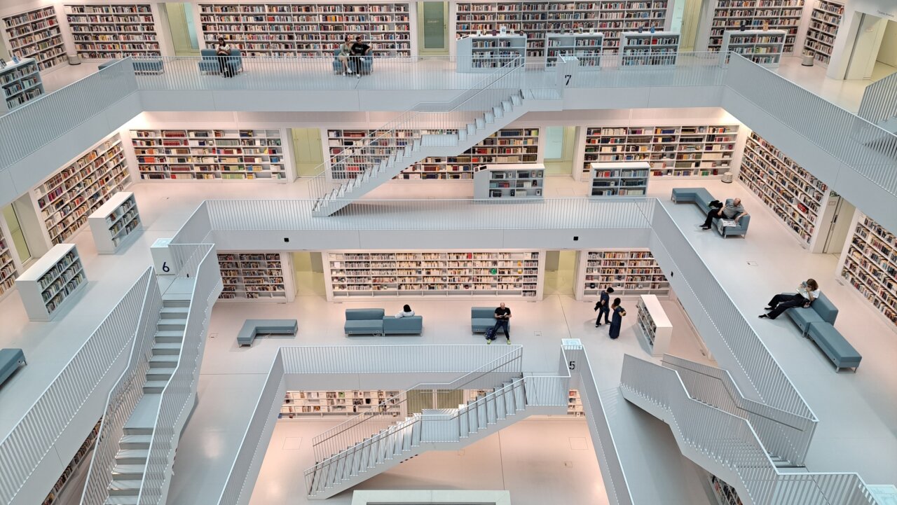 Vista interior de la biblioteca pública de Stuttgart con estanterías y escaleras