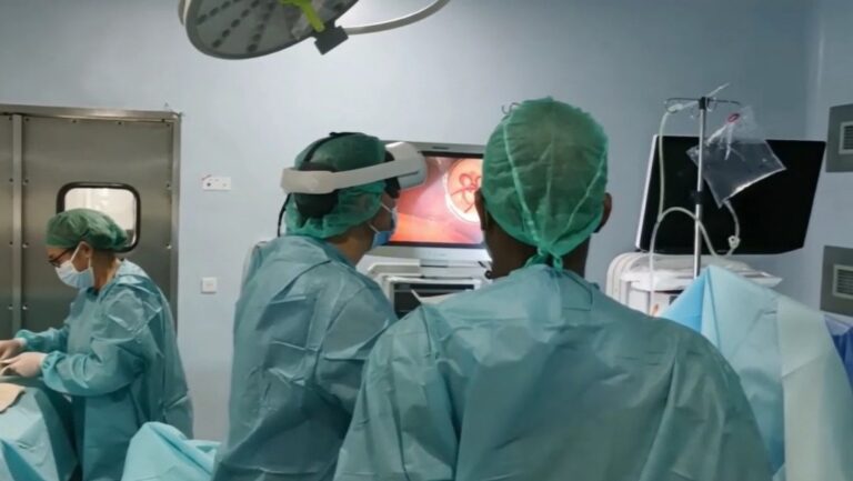 Médico en quirófano utilizando tecnología avanzada para cirugía mínimamente invasiva