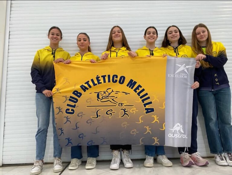 Jugadoras del Club Atlético Melilla sosteniendo una bandera del equipo
