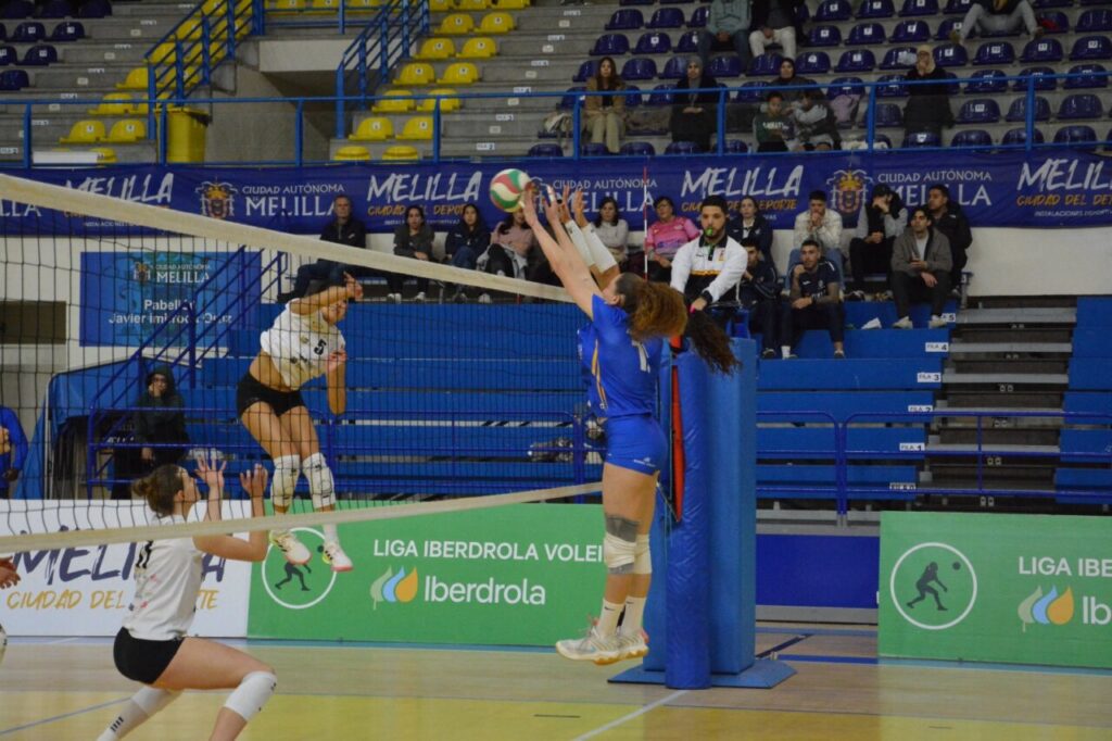 Jugadora del Club Voleibol Melilla saltando para bloquear un remate en un partido