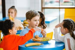 Niños disfrutando de comidas escolares en un ambiente alegre
