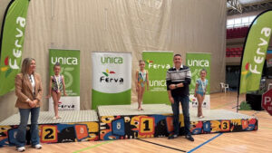 Niñas en podio de competencia de gimnasia con medallas