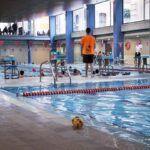 Niños nadando en una piscina durante un evento deportivo