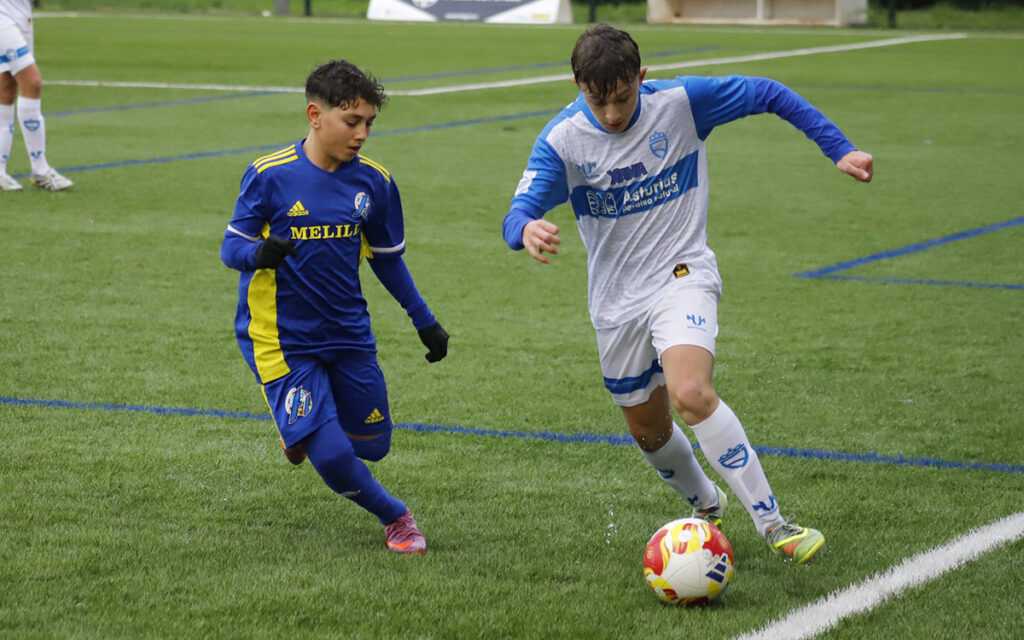Jugadores de fútbol en un partido entre Melilla y Asturias