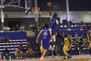 Jugador del Melilla Ciudad del Deporte Enrique Soler realizando un mate en un partido de baloncesto.