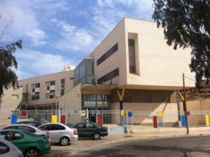 Edificio moderno de una escuela en Melilla con coches aparcados