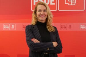 Elena Fernández Treviño posando con los brazos cruzados en un fondo rojo