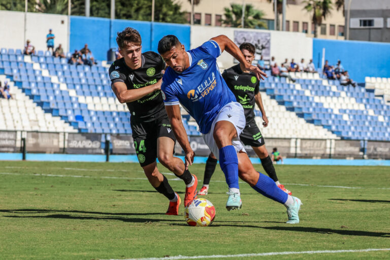 Jugadores de C.D. Extremadura y U.D. Melilla en un partido de fútbol