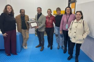 Grupo de personas posando con un premio en un aula