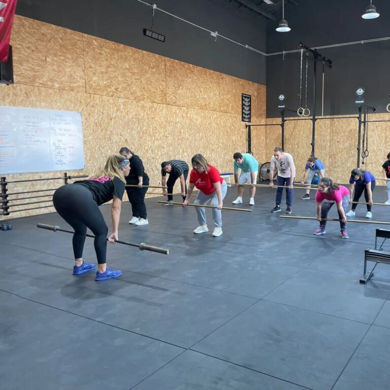 Grupo de personas levantando pesas en un gimnasio