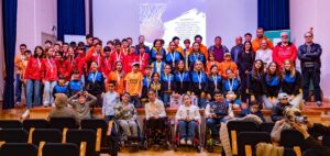 Grupo de niños y adultos en un evento de baloncesto con medallas