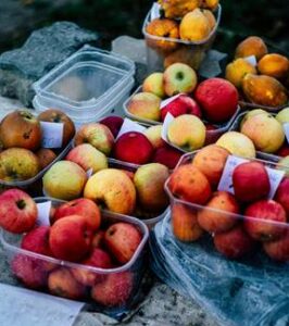 Variedad de frutas frescas en recipientes transparentes sobre una mesa