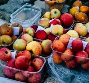 Variedad de frutas frescas en recipientes transparentes sobre una mesa