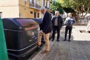 Personas observando un contenedor de residuos en Melilla