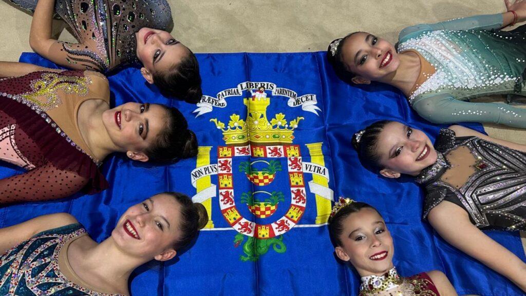 Gimnastas del Club Virka Melilla posando sobre una bandera