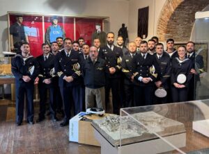 Grupo de militares posando en un museo con uniformes y objetos históricos