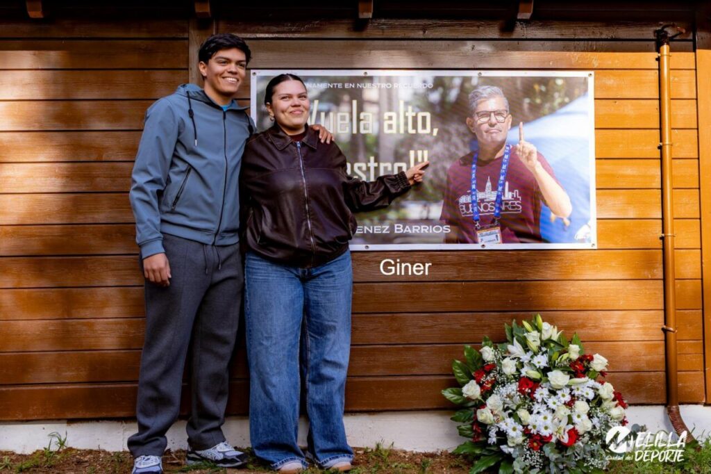 Dos personas posando junto a un cartel en homenaje a Óscar Giménez Barrios