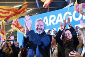 Jorge Azcón celebrando con banderas en un evento del PP en Aragón