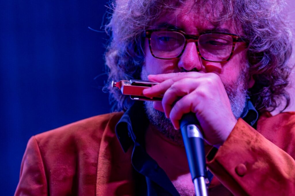 Músico tocando la armónica en un concierto de jazz en la UNED.