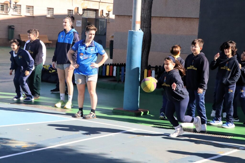 Niños jugando baloncesto en la escuela con entusiasmo.