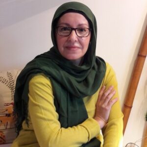 Karima Toufali posando en un ambiente acogedor con un suéter amarillo