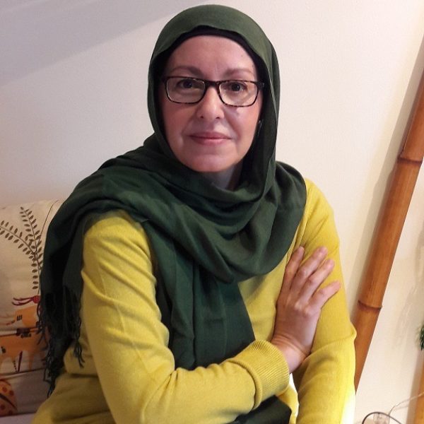 Karima Toufali posando en un ambiente acogedor con un suéter amarillo