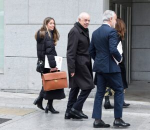 Grupo de personas saliendo de un edificio, con documentos en mano