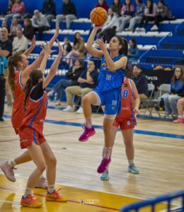 Jugadora del equipo La Salle lanzando a canasta durante un partido de baloncesto