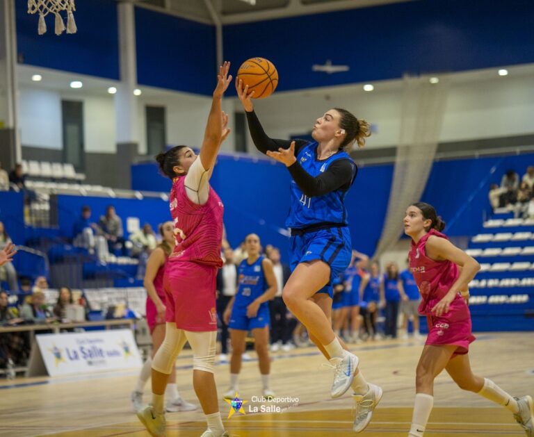 Jugadora lanzando el balón durante un partido de baloncesto femenino.