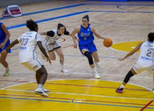 Jugadora del Melilla Ciudad Deporte La Salle con balón en partido de baloncesto